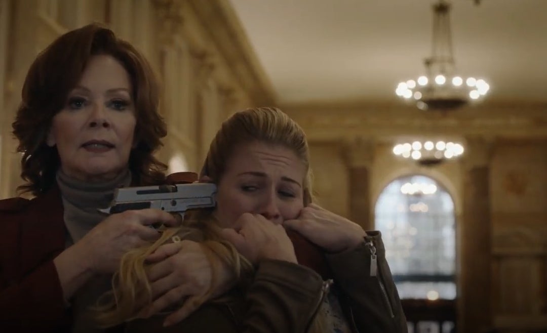 A woman (Jean Smart) holding someone hostage with a gun pointed at the temple of the hostage