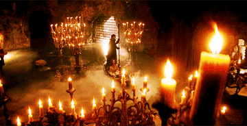 Phantom of the Opera paddling a boat in a cave of candles