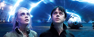 Young man and woman looking up at electrical surge on a spaceship