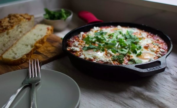 A warm Mexican casserole is served in a Lodge cast iron dish, with the red pot holder on the handle