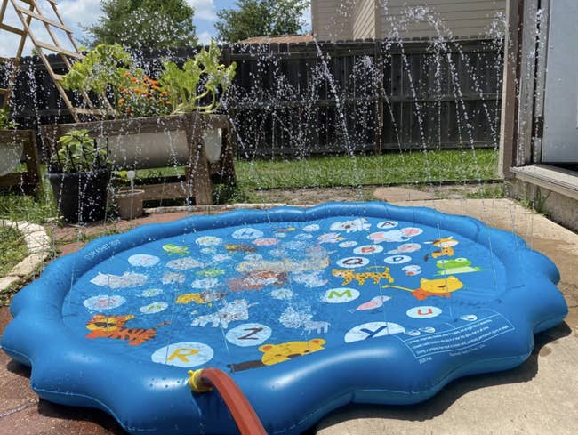 A circular waterproof pad with holes all around it for water to spout out of once someone installs a hose into it 