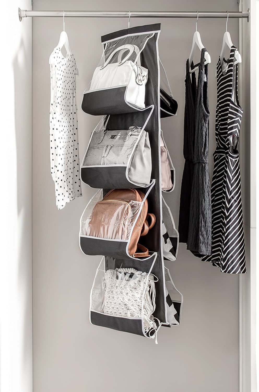 a hanging organizer for eight hand bags in a closet