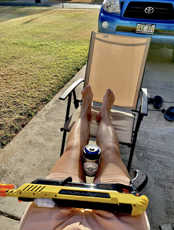 reviewer's pic of resting the salt gun on legs propped up on patio chair