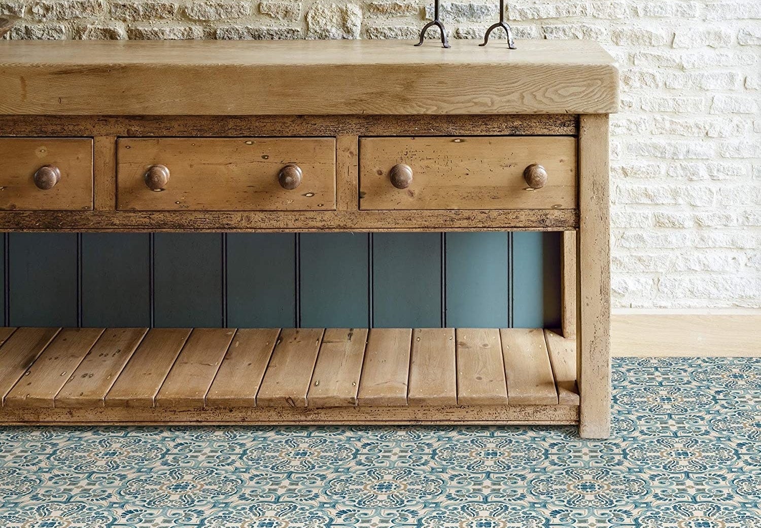 A wooden credenza on a funky patterned tiled floor