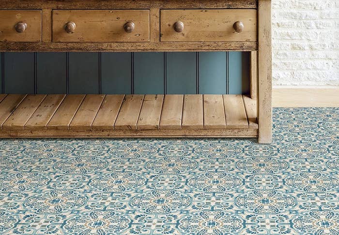 A wooden credenza on a funky patterned tiled floor