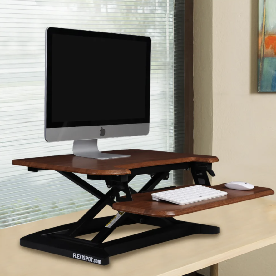 Standing desk converter on wooden table