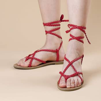 a model wearing the sandals in red