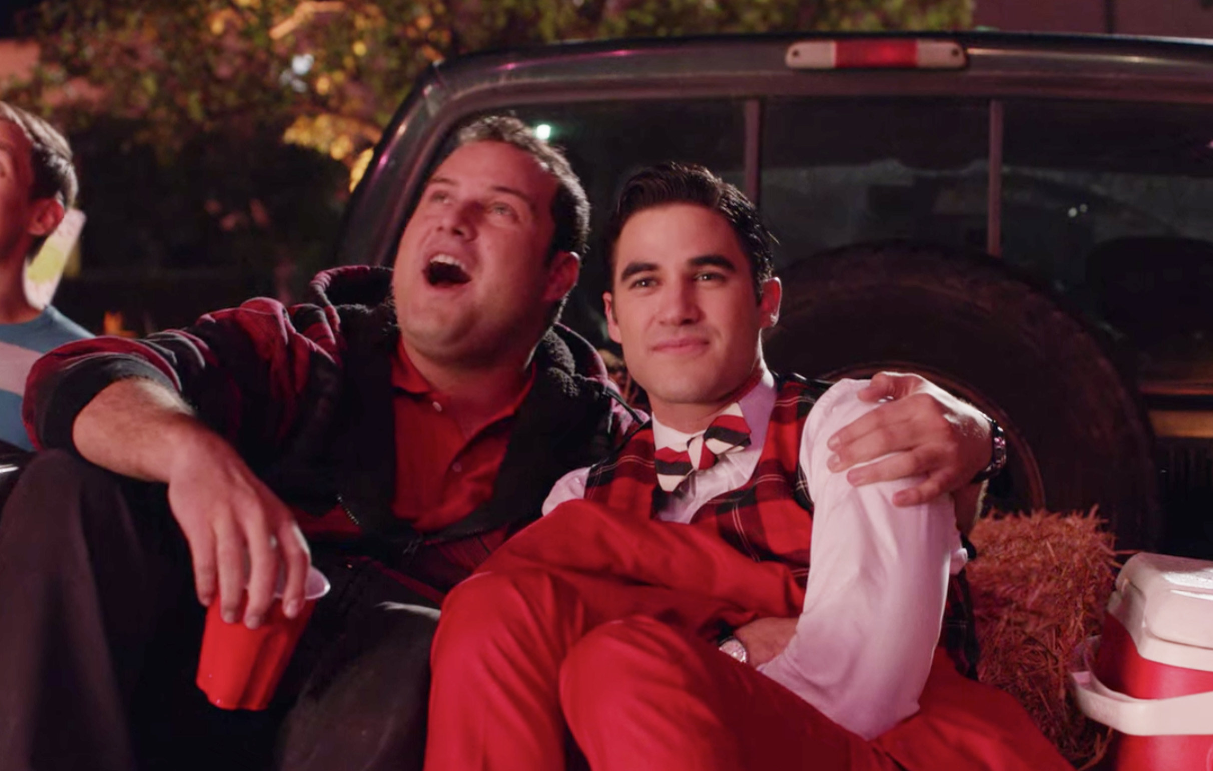 Karofsky holding Blaine as they sit on the back of a truck