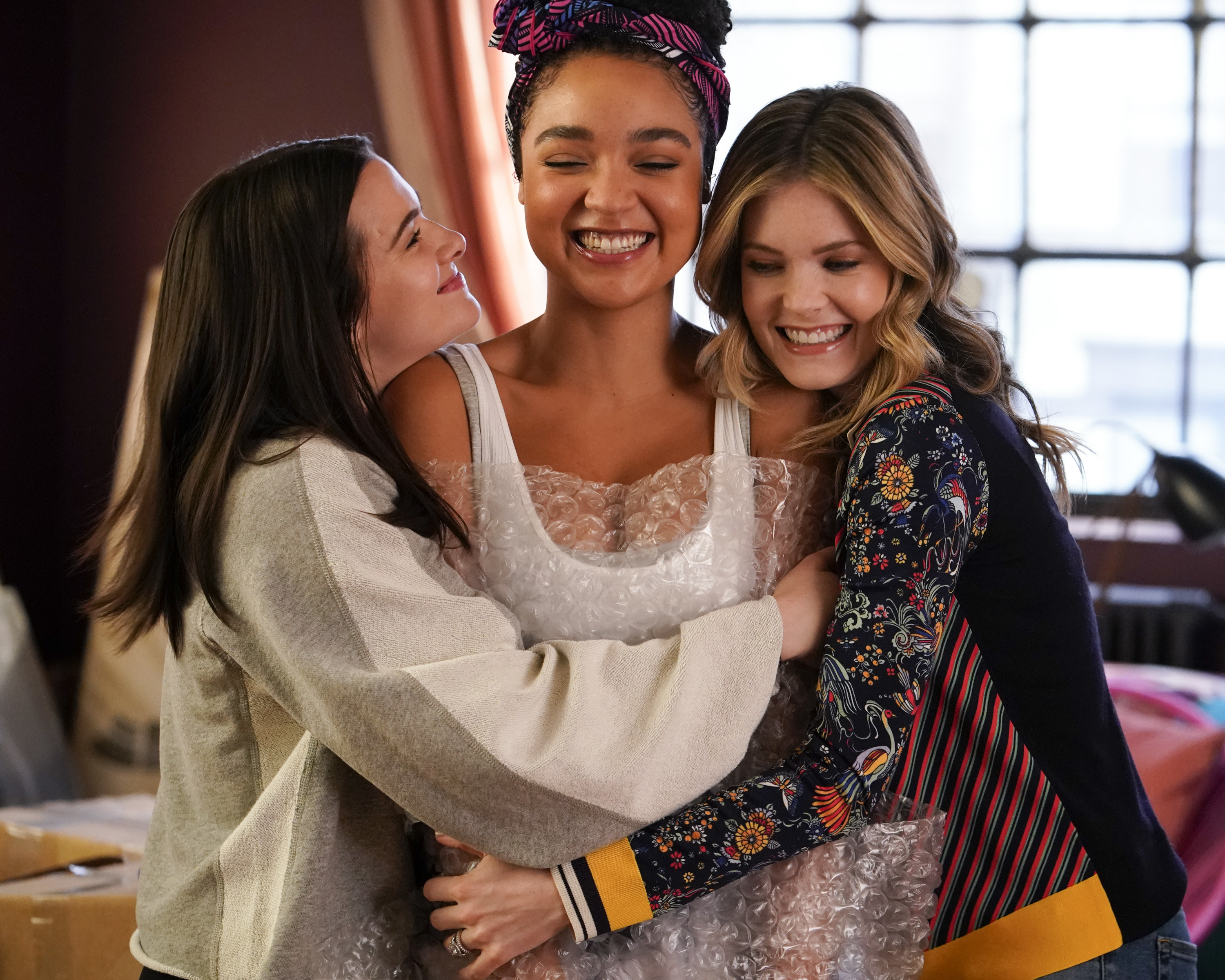 Katie, Aisha, and Meghann hugging during a scene