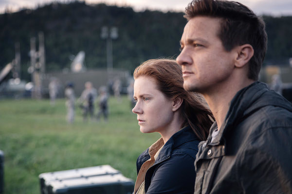 Amy Adams and Jeremy Renner staring into the distance