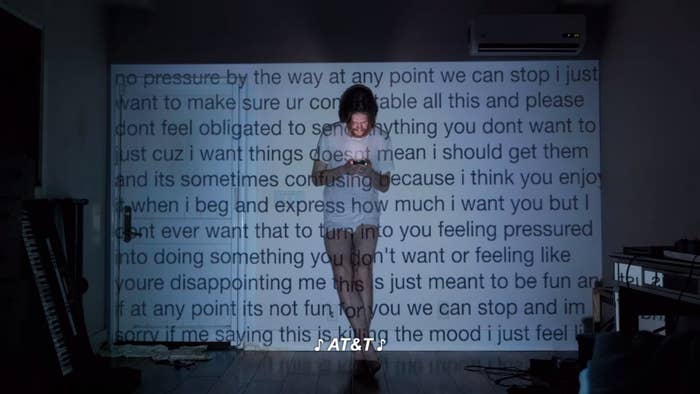 Bo standing in front of projected text that talks about how the person he's sexting shouldn't feel obligated to send him anything