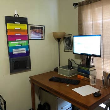 a reviewer photo of a home office with the wall organizer hanging by the desk 