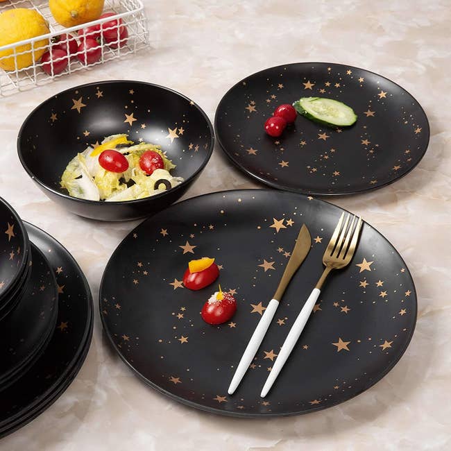 Several matching plates and bowls covered in gold stars 