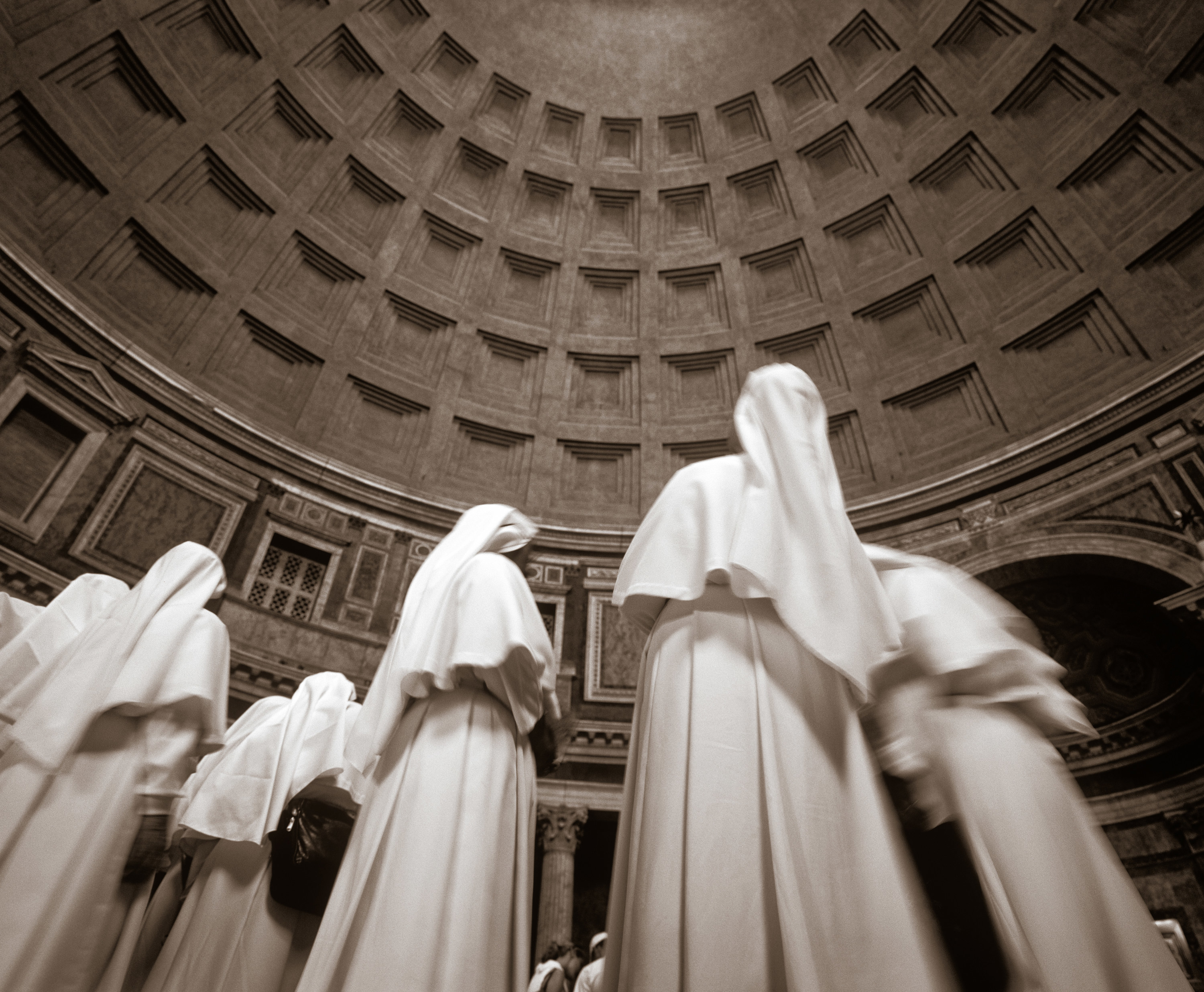 Nuns standing without their faces visible in a pantheon