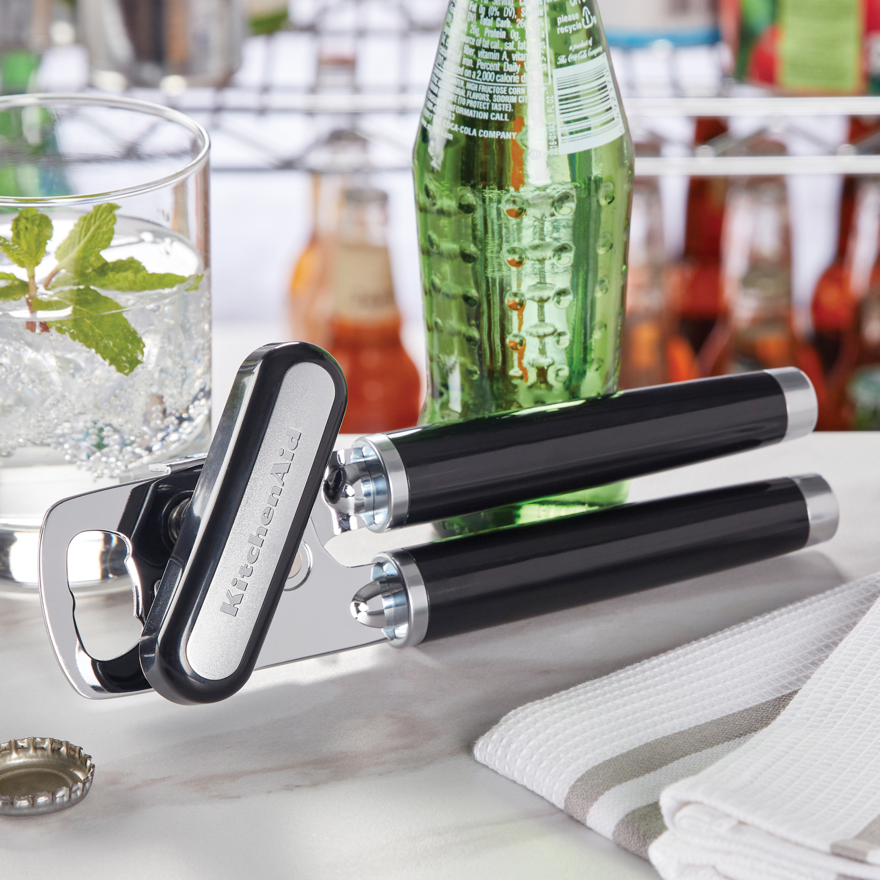 black multifunction can opener on a table next to a bottle