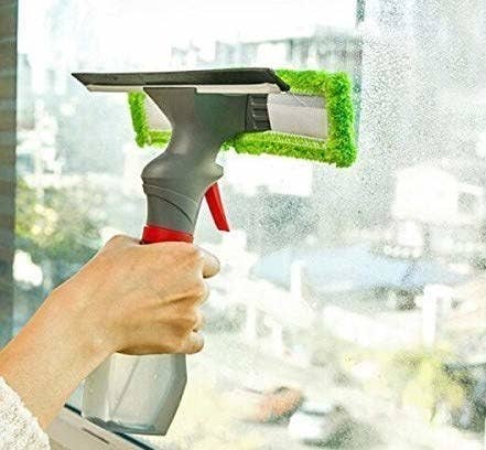 A woman cleaning a window with a glass spray microfibre wiper.