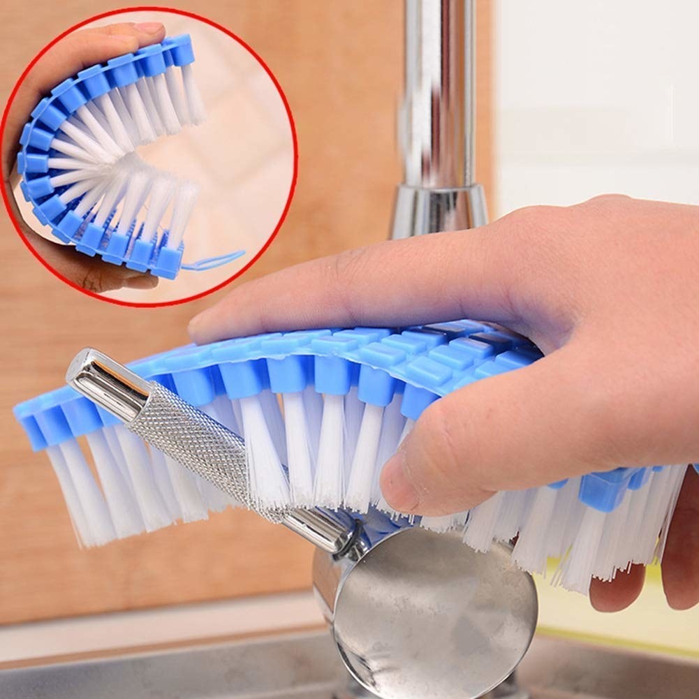 A flexible brush cleaning a stained tap.
