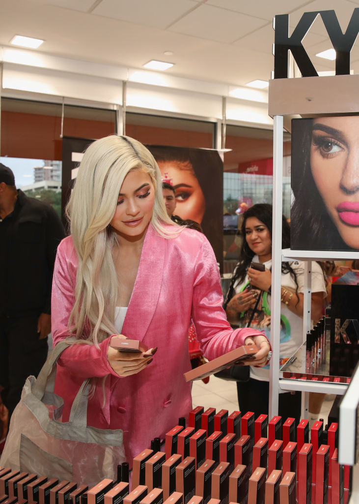 Kylie looking at a display of her makeup products at a store