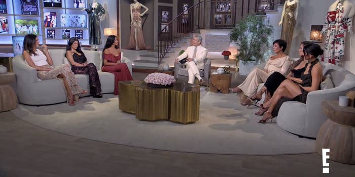 Shot of the Kardashians and Jenners sitting on either side of Andy Cohen