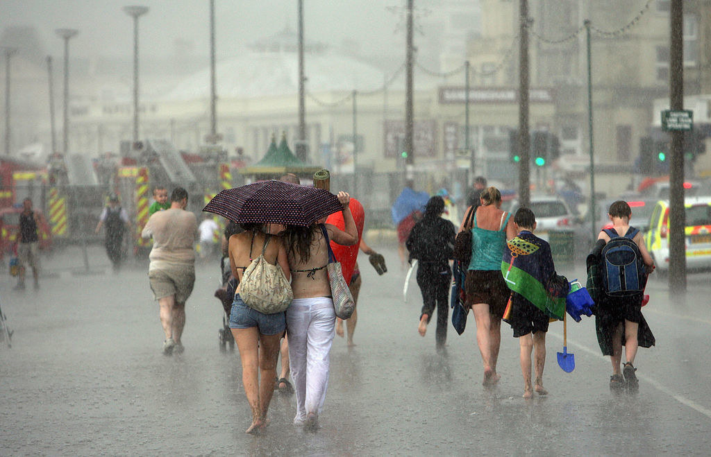 People in England walking on the sidewalk while it&#x27;s raining