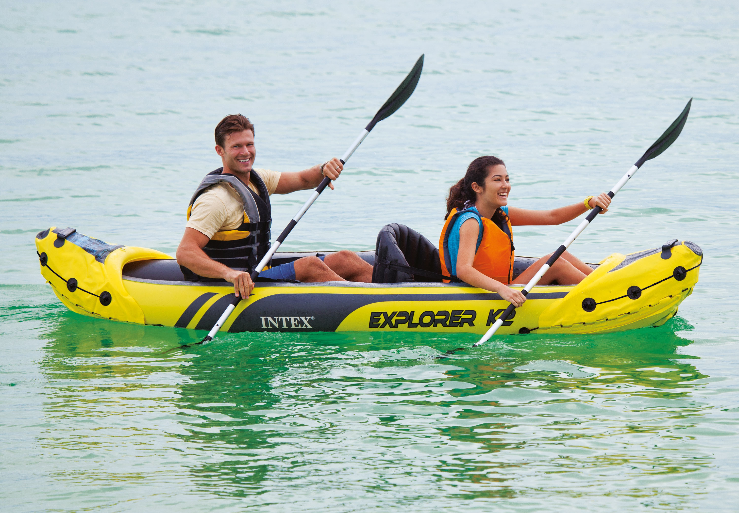 two people in the inflated kayak on a body of water