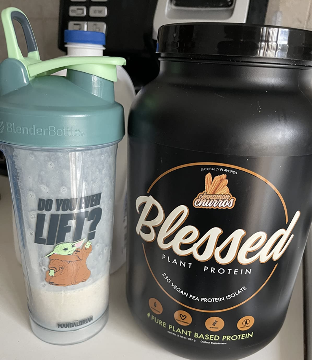 A clear bottle with a Baby Yoda cartoon that says &quot;do you even lift?&quot; next to a bottle of protein powder