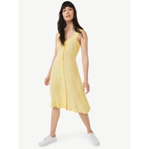 model wearing the dress in yellow with white shoes