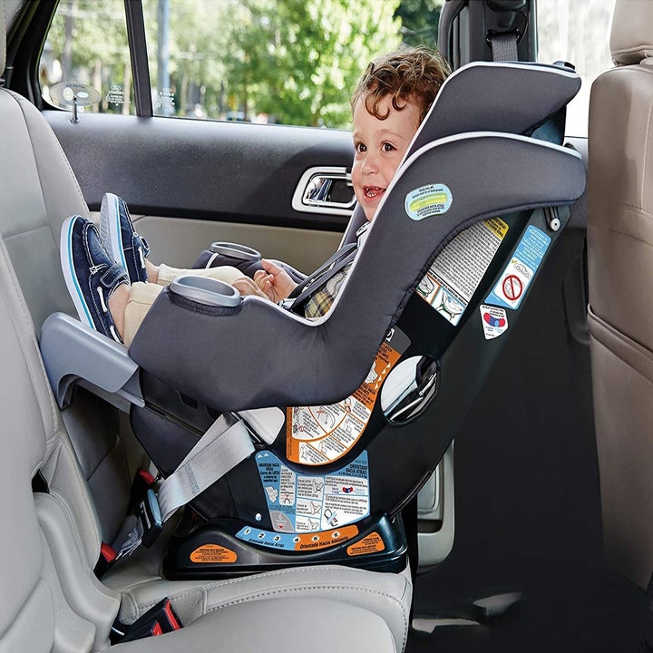 Child model in black and gray rear-facing car seat