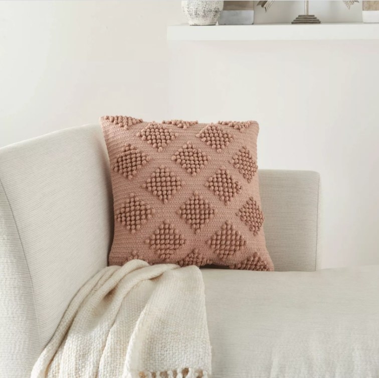 A pink, woven throw pillow