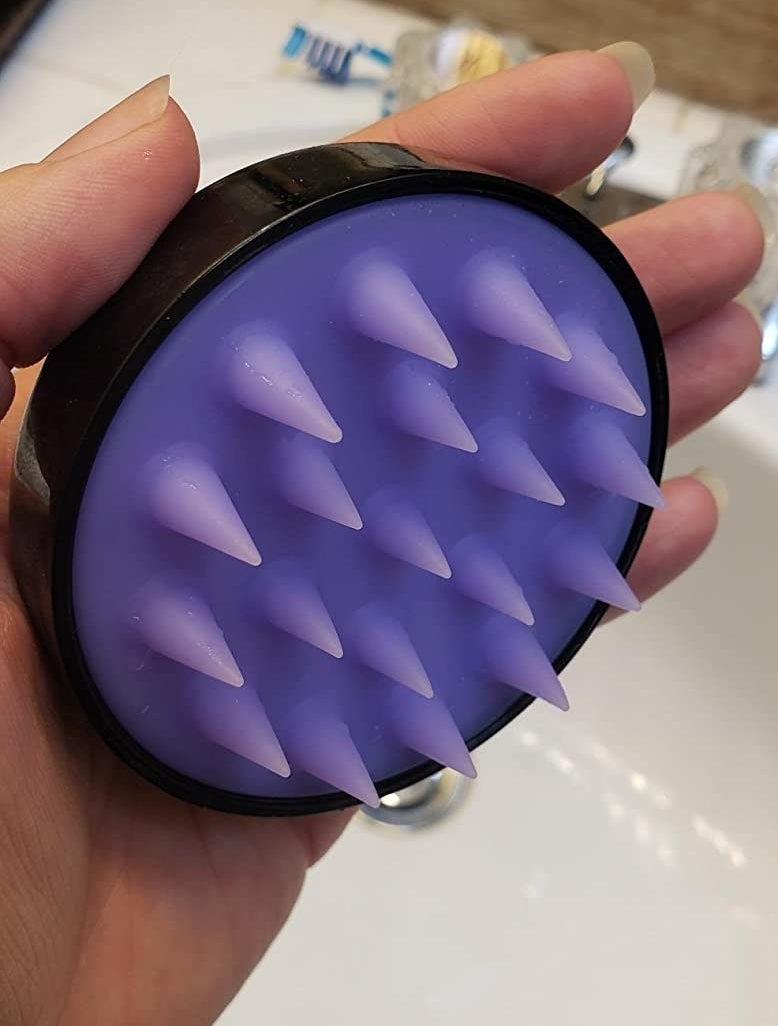 reviewer holding the massager on purple