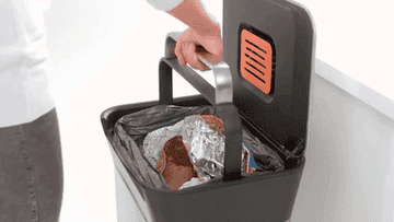 A GIF of a person pressing garbage further into a bin to make more room