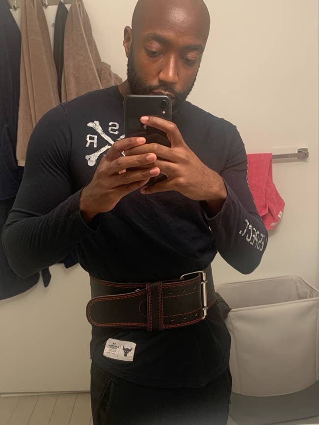 a BuzzFeed Editor wearing the weight-lifting belt