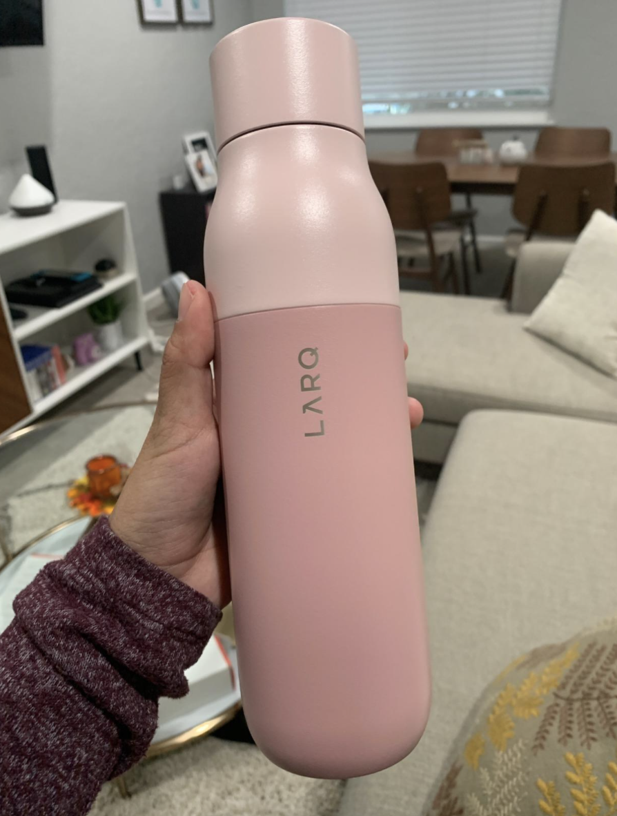 reviewer holding a pink water bottle