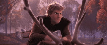 a gif of kristoff from frozen rushing through the woods on a reindeer