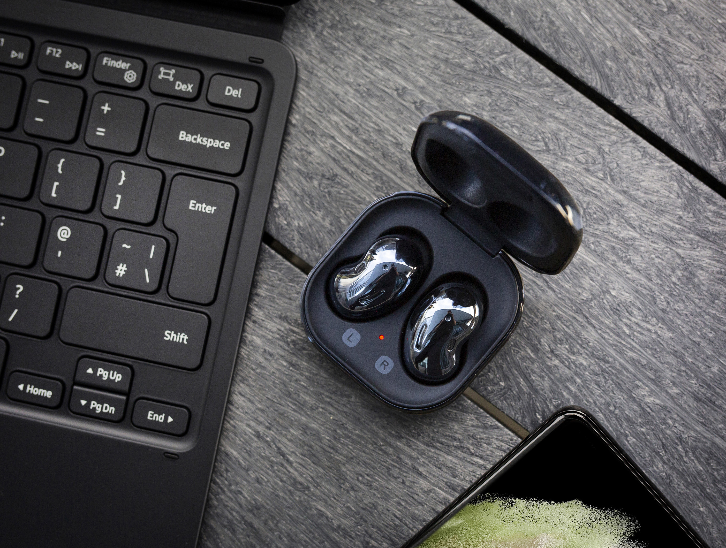 A pair of earbuds next to a laptop keyboard