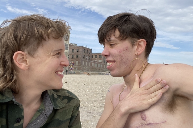Two trans people smile at each other at Riis Beach, NYC