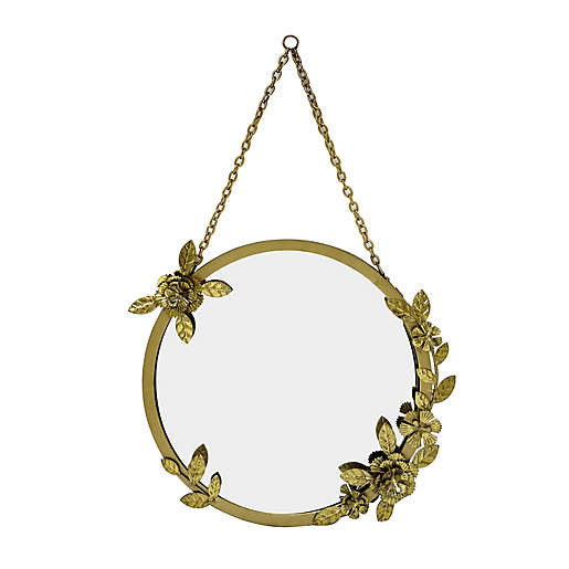 A circular golden mirror with flower accents on the frame.