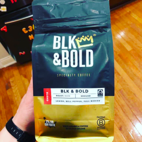 reviewer&#x27;s hand holding a bag of Blk and bold coffee