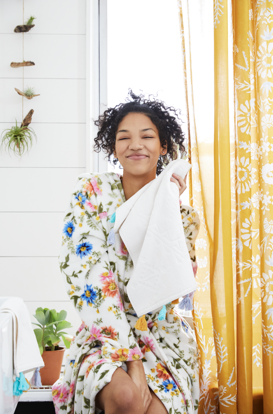 Woman in floral print fluffy robe in her bathroom.