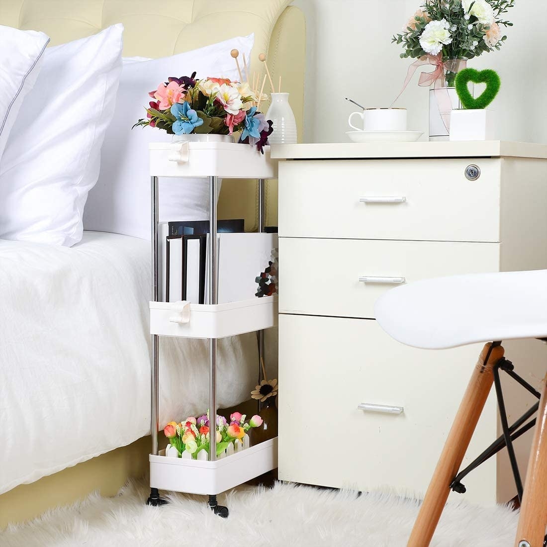 Three-tiered storage cart placed between bed and bedside table