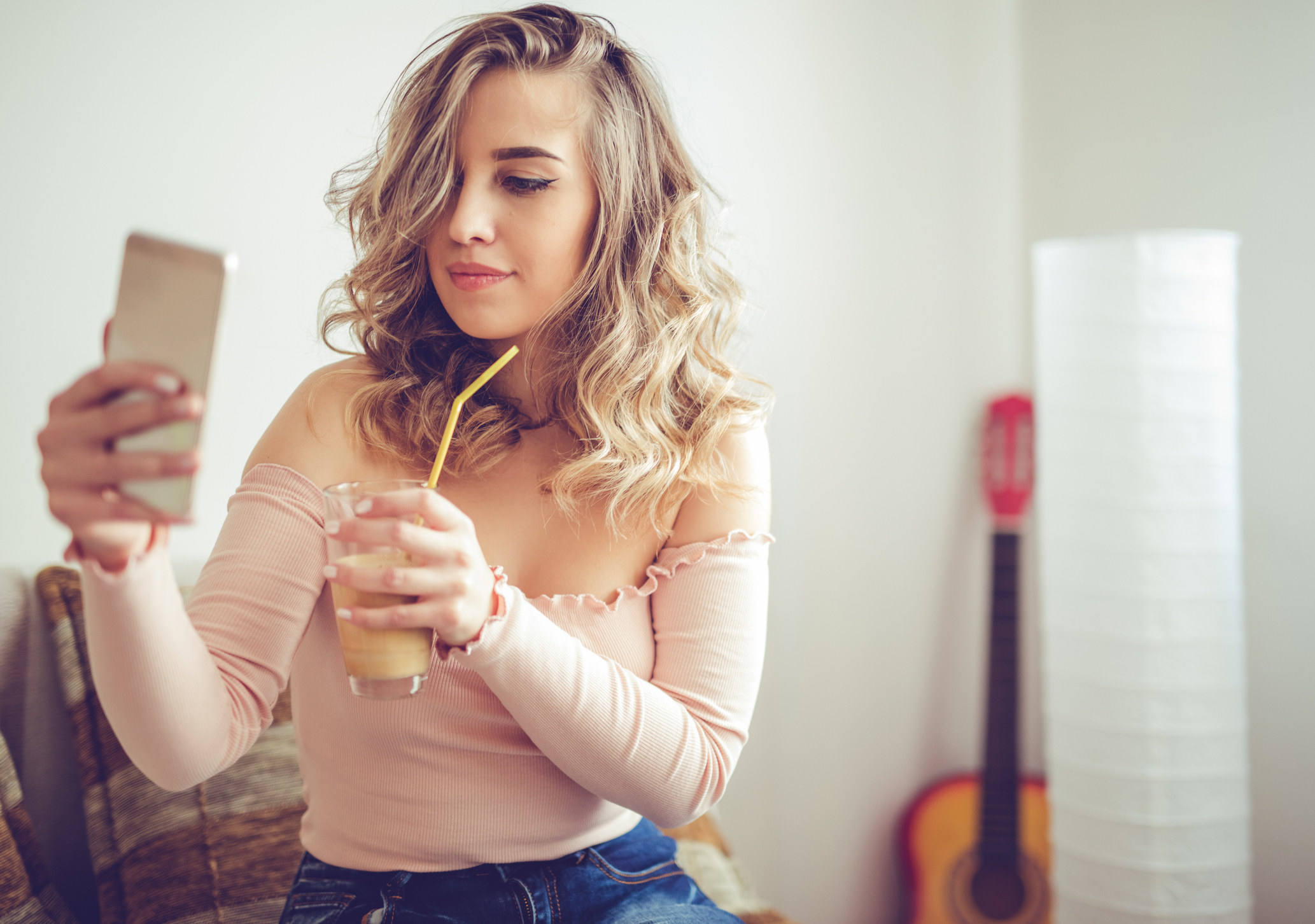 Young blond woman uses mobile phone on a coffee break