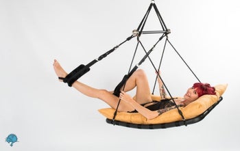 Model lounging in swing with yellow cushion