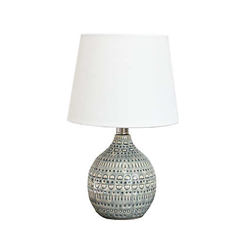 A patterned grey table lamp with white shade.