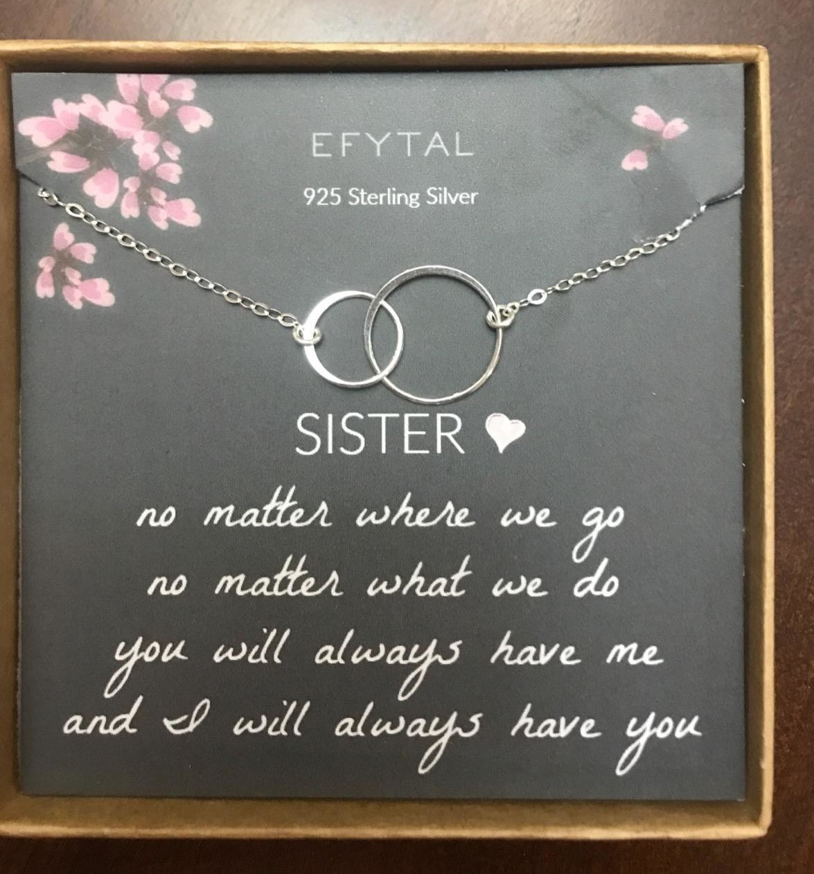 Reviewer photo of the interlocking circles necklace with the &quot;sister&quot; themed message it comes with