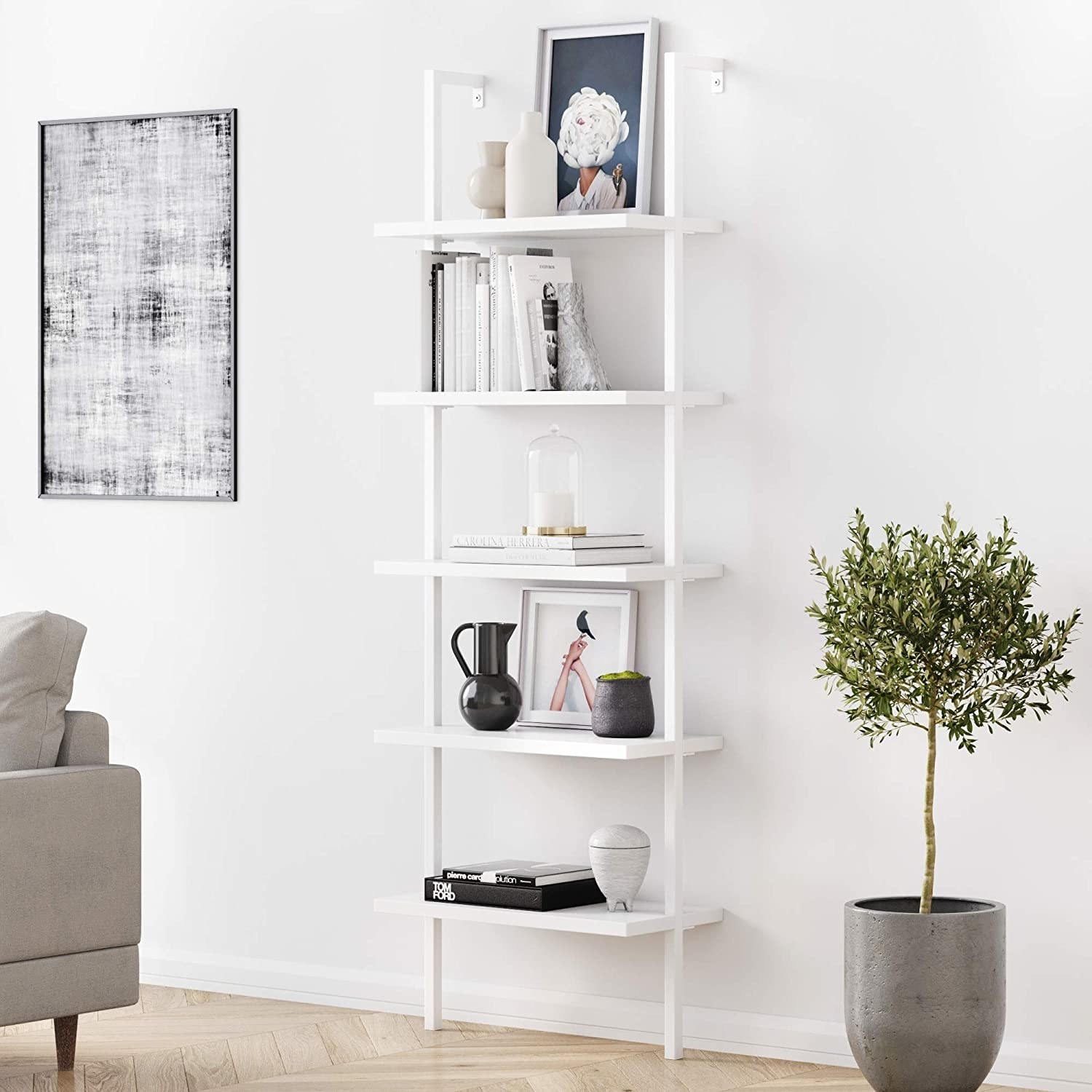 White industrial bookshelf on white wall with various decorative items and books