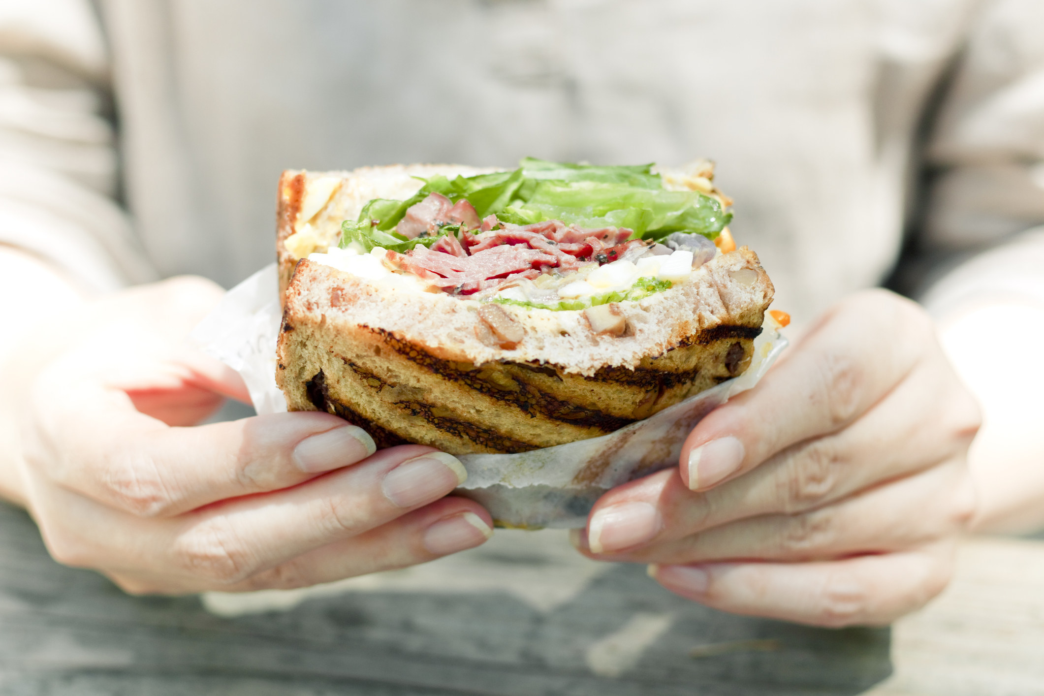 Someone holds a sandwich, about to eat it