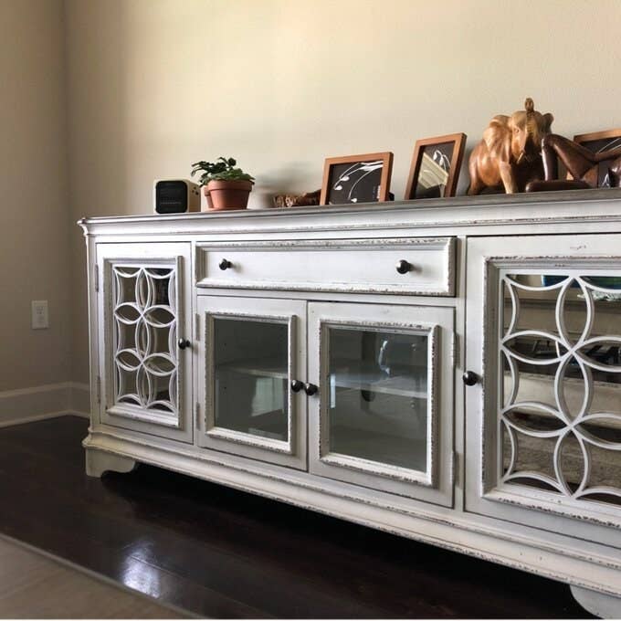 The credenza with photos and plants on top