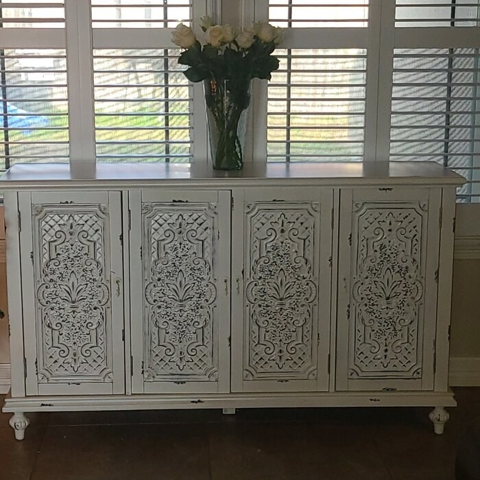 The credenza with a vase of white roses on top