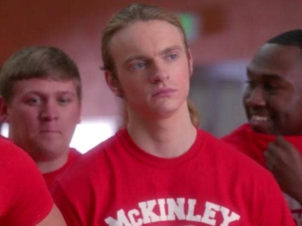 Alistair stands amongst his male peers in the McKinley High gym class.