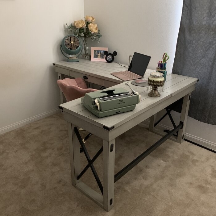 The L-shaped desk with office supplies on top